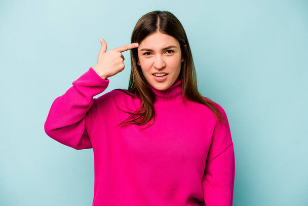 Young caucasian woman isolated on blue background showing a disappointment gesture with forefinger. - Foto, imagen