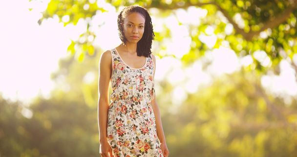 Молода чорна жінка стоїть в парку
 - Фото, зображення