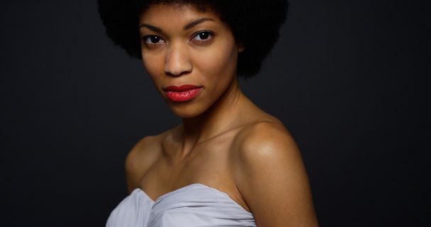 Attractive black woman wearing elegant gown looking at camera - Фото, зображення