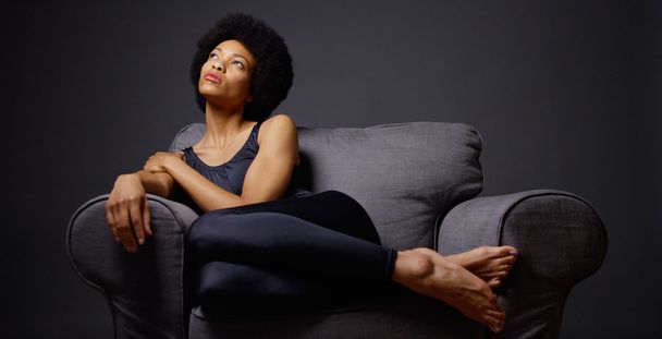 Black woman sitting in armchair - Zdjęcie, obraz