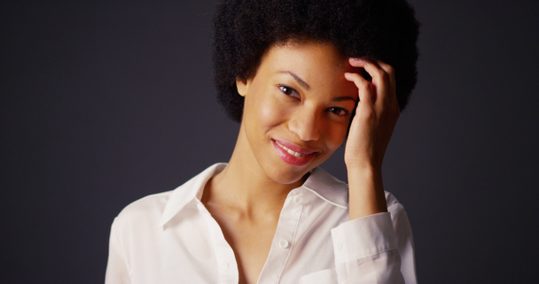 Привлекательная молодая черная женщина с афро, смотрящая в камеру
 - Фото, изображение