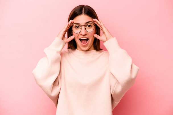 Young caucasian woman isolated on pink background receiving a pleasant surprise, excited and raising hands. - Photo, Image