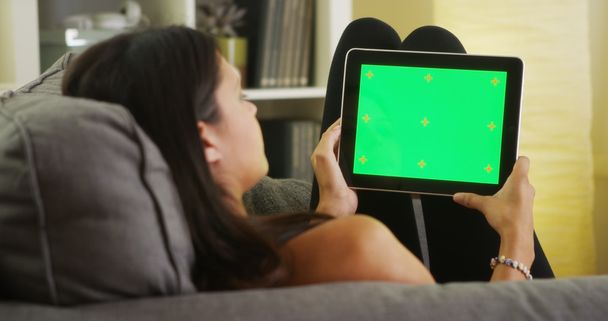 Дівчина змішаної раси дивиться на планшет з зеленим екраном
 - Фото, зображення