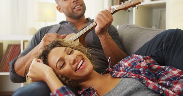 Zwarte vriendin genieten van wordt te serenade door vriend - Foto, afbeelding