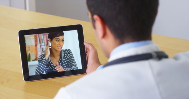 Spaanse arts praten met jonge vrouw patiënt op Tablet PC - Foto, afbeelding