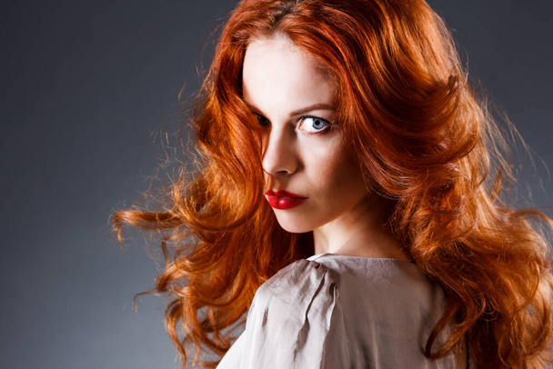 Dlouhé kudrnaté rudé vlasy. Portrét módní ženy. Beauty Model Girl s luxusními vlasy, make-up a doplňky. Účes. Koncept rozšíření vlnitých vlasů. Prázdninový make-up. Kouřící oči a červená rtěnka - Fotografie, Obrázek