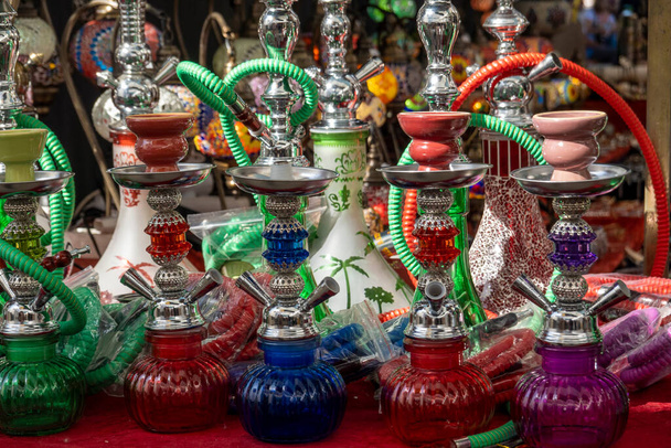 Several colorful tobacco waterpipes at sale in a islamic event market. - Photo, Image