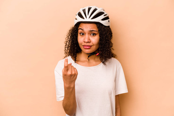 Jovem hispânica vestindo uma bicicleta capacete isolado no fundo azul apontando com o dedo para você como se convidativo chegar mais perto. - Foto, Imagem