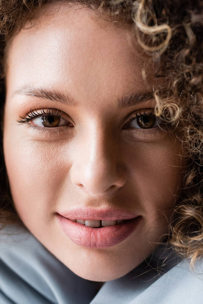 close up view of smiling woman with natural makeup and brown eyes looking at camera - Photo, image