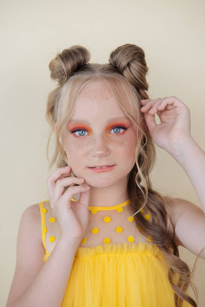 okouzlující blondýny tween dívka s oranžovým make-up na žlutém pozadí. portrét teenagera. - Fotografie, Obrázek