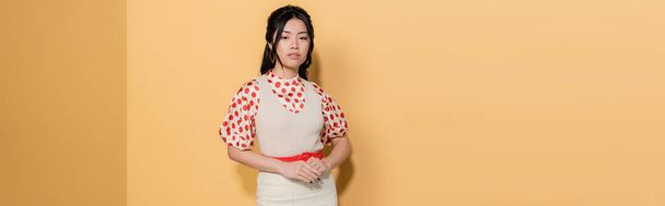 Fashionable asian woman in dress and blouse on orange background, banner  - Fotografie, Obrázek
