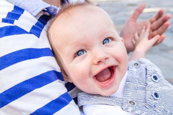 Bébé garçon sourit largement tout en tenant la main de son père dans un parc en été
 - Photo, image