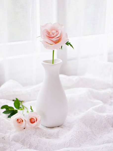 Rosa Pastellrosenblüten in der Vase auf dem Tisch mit besticktem Tuch, Stillleben für Hintergrund oder Tapete, Hochzeitskonzept, Muttertag, Frauentag, weiche Farbe, romantische schöne Karte Kopierraum  - Foto, Bild