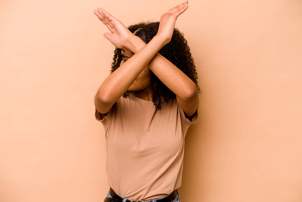 Genç Afrikalı Amerikalı kadın bej arka planda izole edilmiş iki kolu çapraz tutuyor, inkar kavramı. - Fotoğraf, Görsel