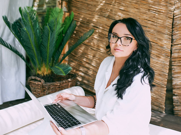 眼鏡の美しい女性起業家のフリーランスは、リモートで動作します。教育、旅行、ビジネスコンセプト  - 写真・画像