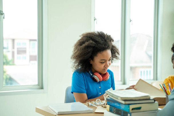 Afrikai-amerikai lány iskolás gyerekek együtt tanulnak az osztályteremben. A feladaton dolgozó iskolás gyermekek csoportjai, az általános iskolában tesztelő diákok. - Fotó, kép