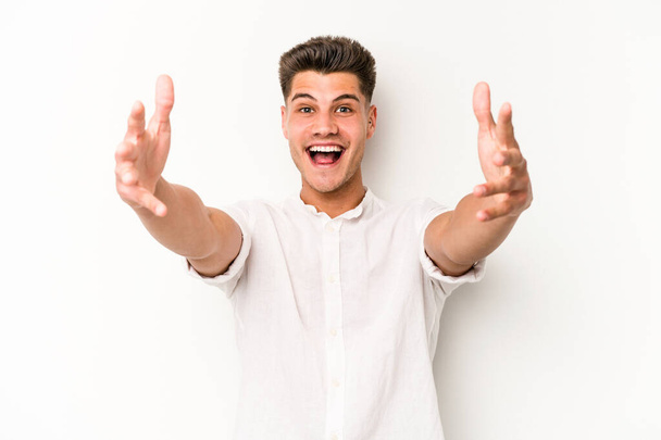 Young caucasian man isolated on white background celebrating a victory or success, he is surprised and shocked. - Photo, Image