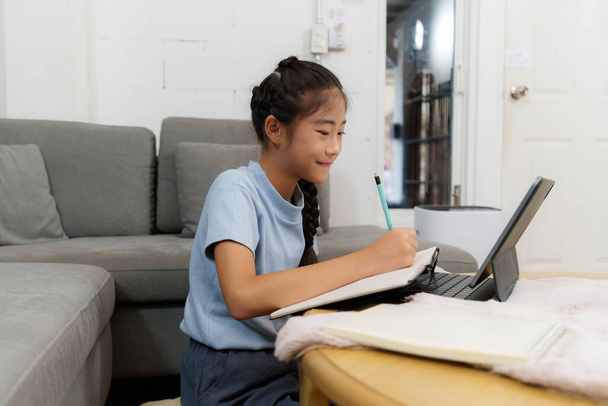 Homeschool Azjatycka matka i mała dziewczynka uczą się online klasy. Koncepcja e-learningu Edukacja online. - Zdjęcie, obraz