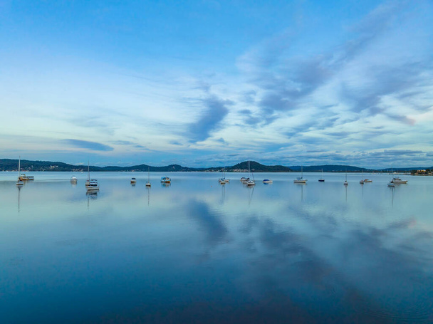 Soft blue sunset with boats, clouds and reflections at Koolewong and Tascott on the Central Coast, NSW, Australia. - Foto, Imagen