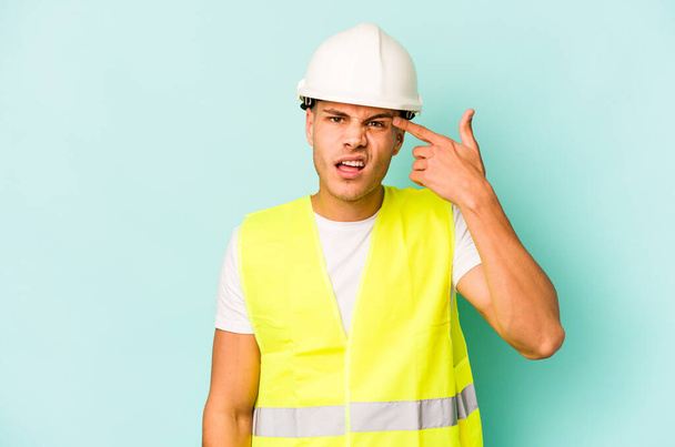 Young laborer caucasian man isolated on blue background showing a disappointment gesture with forefinger. - Foto, Imagem