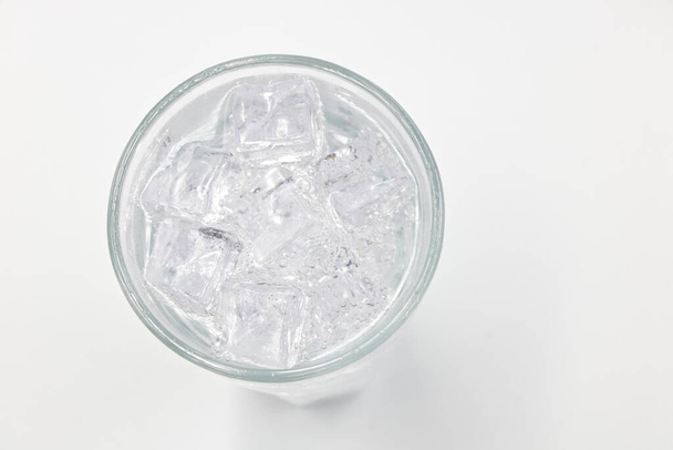 Soda sprankelend water met ijs in glas over witte achtergrond.  - Foto, afbeelding