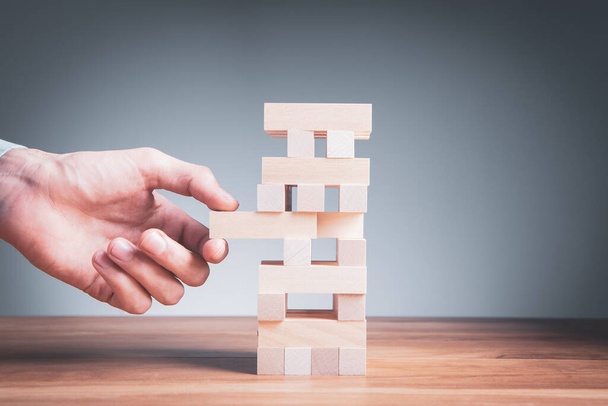 Closeup of a businessman making a structure with wooden cubes. Building a business concept. - Photo, image
