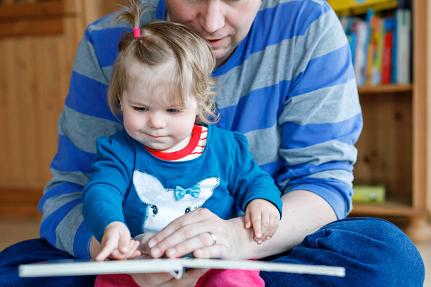 Портрет батька-кавказу тримає сюжетну книгу, читаючи з дочкою маленькою дівчинкою. Домашня школа вчиться від вчителя, освіта щаслива сім'я кохання разом, час ліжка історія батьки концепція дня
 - Фото, зображення