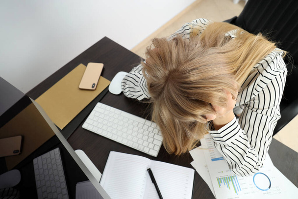 Jeune femme d'affaires fatiguée assise sur le lieu de travail - Photo, image
