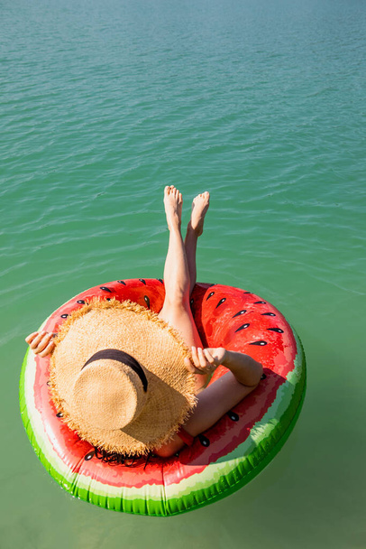 mulher bonita que flutua no anel inflável na água azul do lago verão dia ensolarado - Foto, Imagem