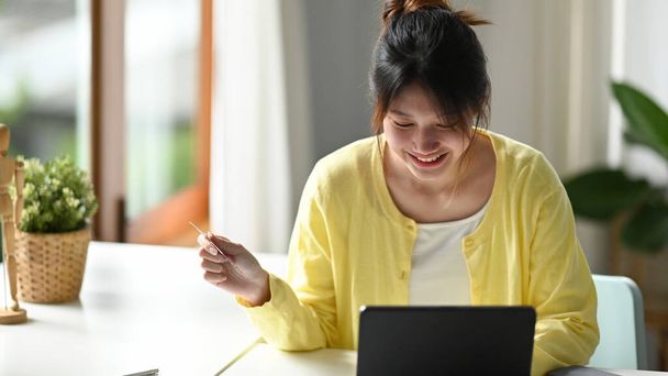 Szczęśliwa azjatycka kobieta zakupy online, za pomocą usługi bankowości internetowej na tablecie - Zdjęcie, obraz