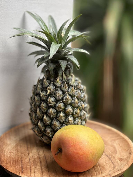  熱帯の板の上のパイナップルとマンゴー - 写真・画像