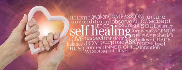 Self Help Healing Word Cloud - vrouwelijke handen met een lichtroze hartvormig houten frame naast een ZELF Healing word wolk tegen een roze oranje energieveld achtergrond  - Foto, afbeelding