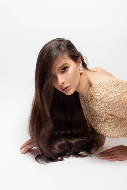 Modeporträt der schönen stilvollen brünetten Modell Frau mit langen dunklen Haaren auf weißem Hintergrund - Foto, Bild