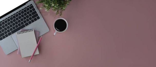 フラットレイアウトノートパソコン、コーヒーカップ、ノートブック、ピンクの背景に鉢植え。スペースのコピー. - 写真・画像