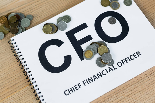 close up view of coins near notebook with cfo lettering on desk - 写真・画像