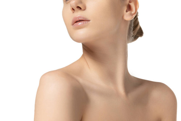 Cropped image of slim, tender womans neck and shoulders isolated over white studio background. Female natural beauty concept - Foto, afbeelding
