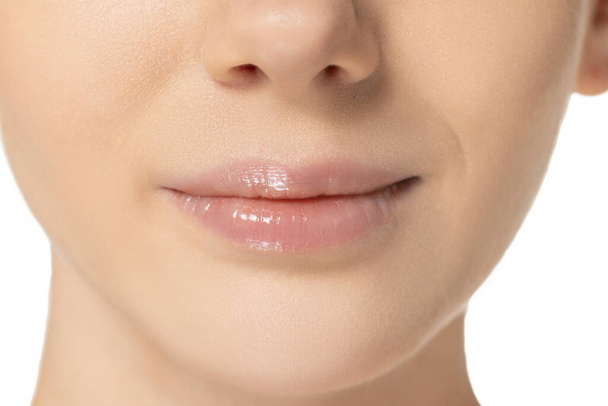 Cropped close-up image of plump female lips isolated over white background. Cosmetology injection, lip augmentation - Fotografie, Obrázek