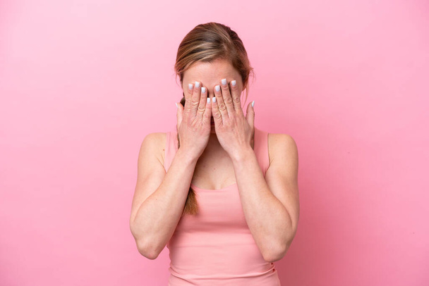 Young caucasian woman isolated on pink background with tired and sick expression - Foto, imagen