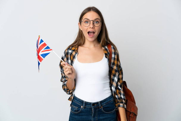 Junge Litauerin mit britischer Flagge auf weißem Hintergrund und überraschendem Gesichtsausdruck - Foto, Bild