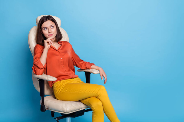 Portrait of attractive minded confident girl sitting in armchair thinking copy blank space isolated over bright blue color background - Foto, immagini