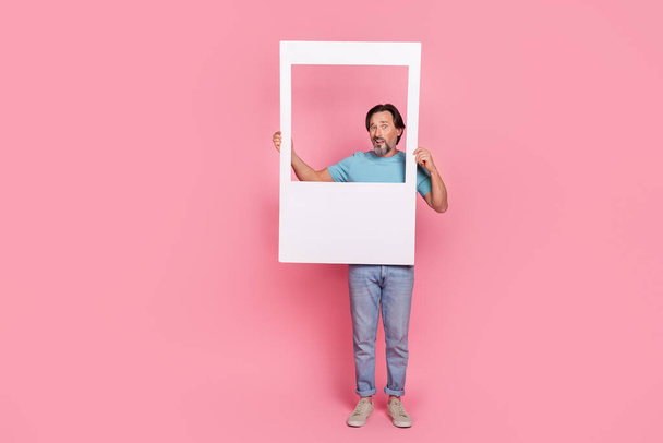 Full body portrait of puzzled person hold paper album set card isolated on pink color background - Foto, imagen