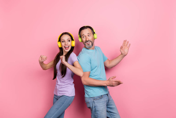 Photo of two excited crazy people enjoy listen favorite song dancing isolated on pink color background - Foto, imagen