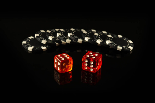 Craps ist ein Würfelspiel, bei dem die Spieler auf die Ergebnisse eines Würfelpaares wetten. Schwarze Chips als Ergebnis des Gewinns erhalten. - Foto, Bild
