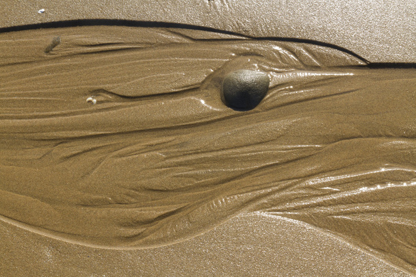 Szlaki wodne w piasku na plaży z kamyczków. - Zdjęcie, obraz