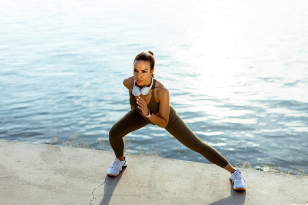 Mulher bonita em sportswear exercitando-se em um passeio no rio - Foto, Imagem