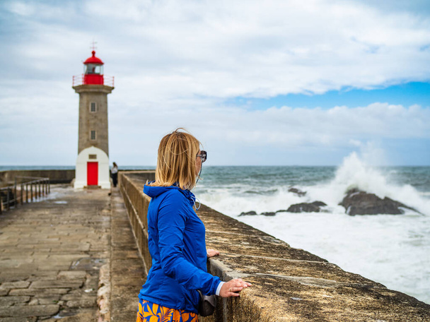 Woman standing by the stormy sea - Photo, Image