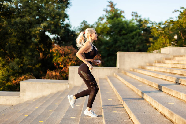 Fitness-Frau rennt frühmorgens die Treppe hinauf. Gesunder Lebensstil - Foto, Bild