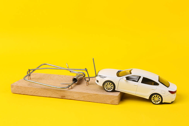 Model hraček s pastí na myši na žlutém pozadí. Skryté problémy při nákupu auta - Fotografie, Obrázek