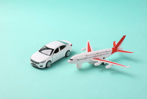 Mavi arka planda uçak olan oyuncak araba modeli. Seyahat kavramı - Fotoğraf, Görsel