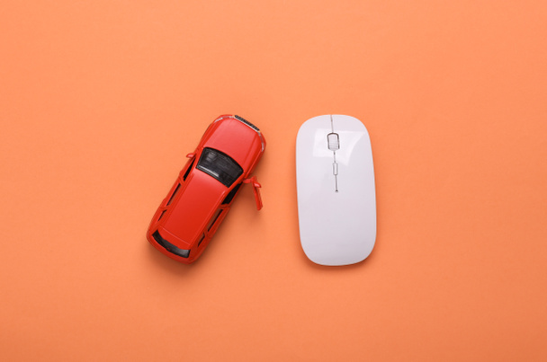 Modelo de juguete auto y ratón PC sobre fondo de color coral. Pedido de coche online - Foto, imagen